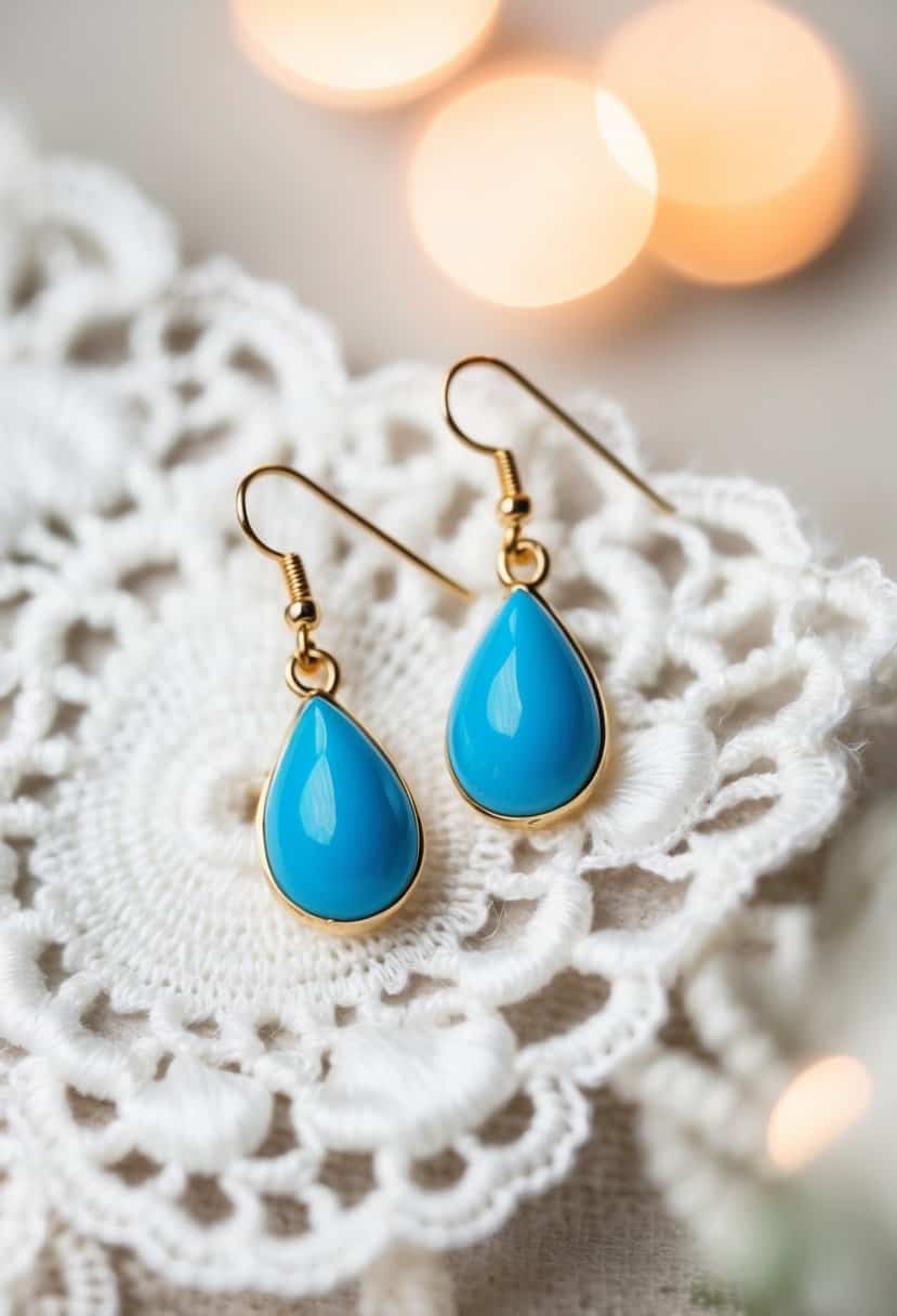 Two cerulean blue drop earrings on a white lace background with soft lighting