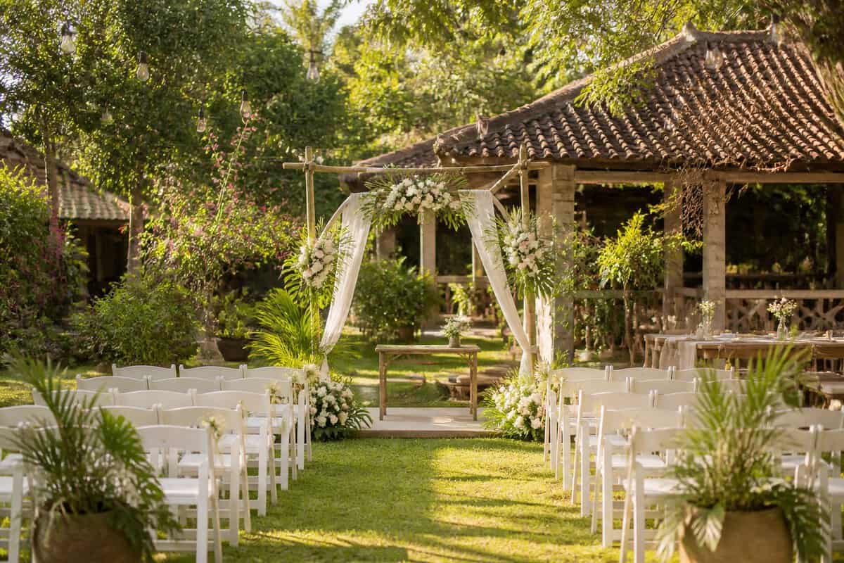 A simple outdoor wedding ceremony setup in a lush tropical Philippine garden.