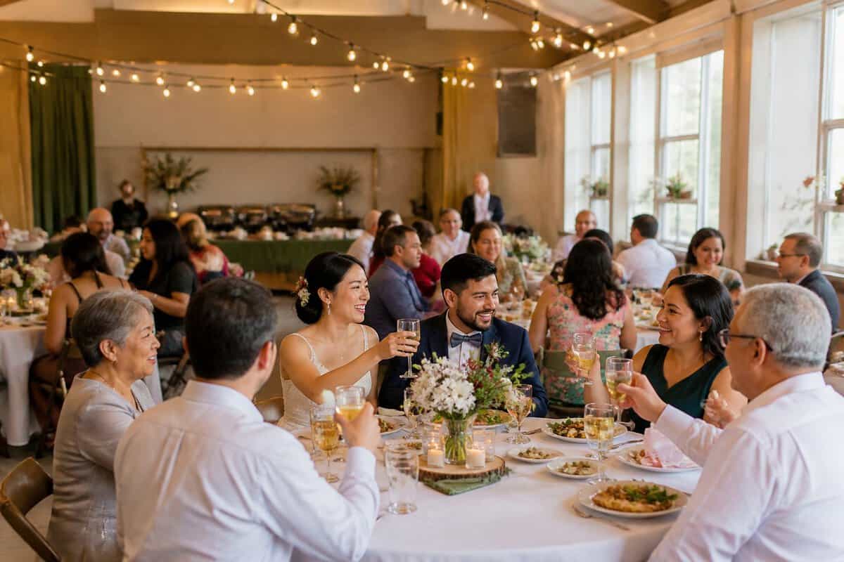 A newlywed couple celebrates with family and friends at a modest community hall reception.