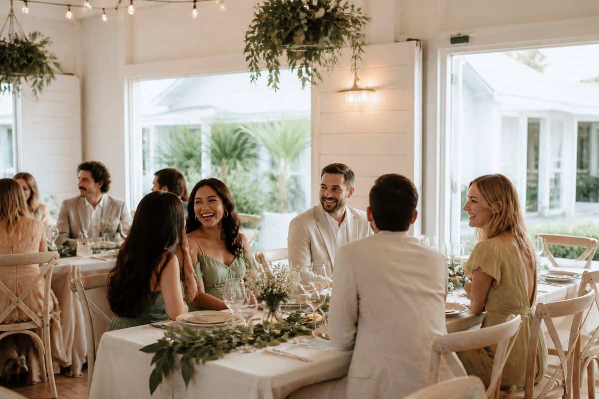 Wedding guests enjoying an elegant reception in a bright, modestly decorated Brisbane venue.