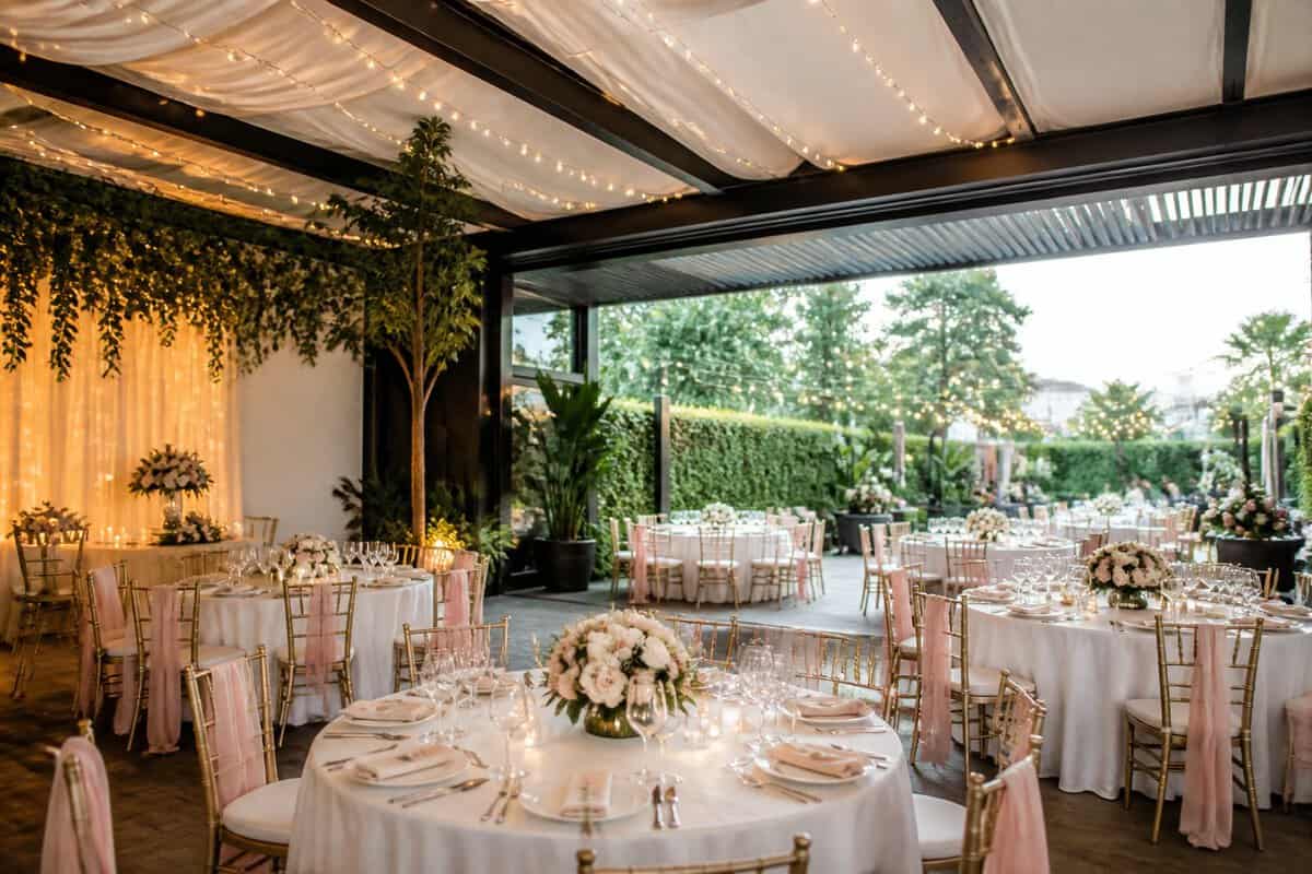 A warmly decorated wedding reception venue with flexible seating, floral centerpieces, and an adjoining garden terrace.