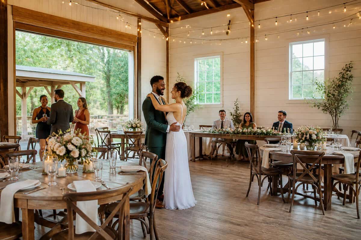 A couple and guests celebrate in an inviting wedding reception venue with simple elegant decorations.