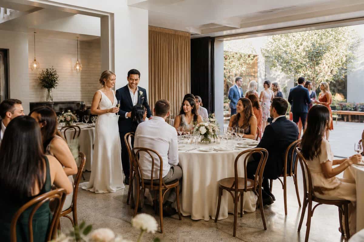 A couple welcomes guests at an intimate wedding reception in a flexible event venue.