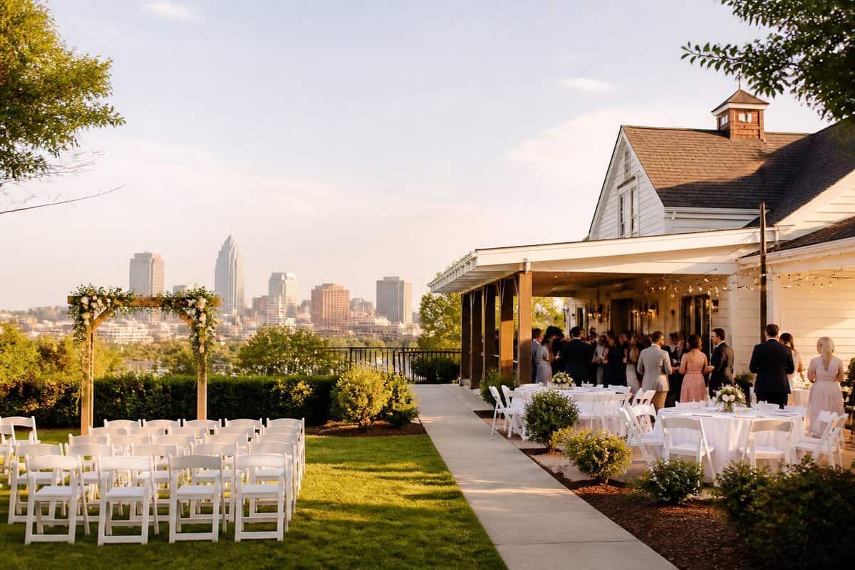 A modest wedding venue with a simple outdoor ceremony setup and a city skyline in the background.