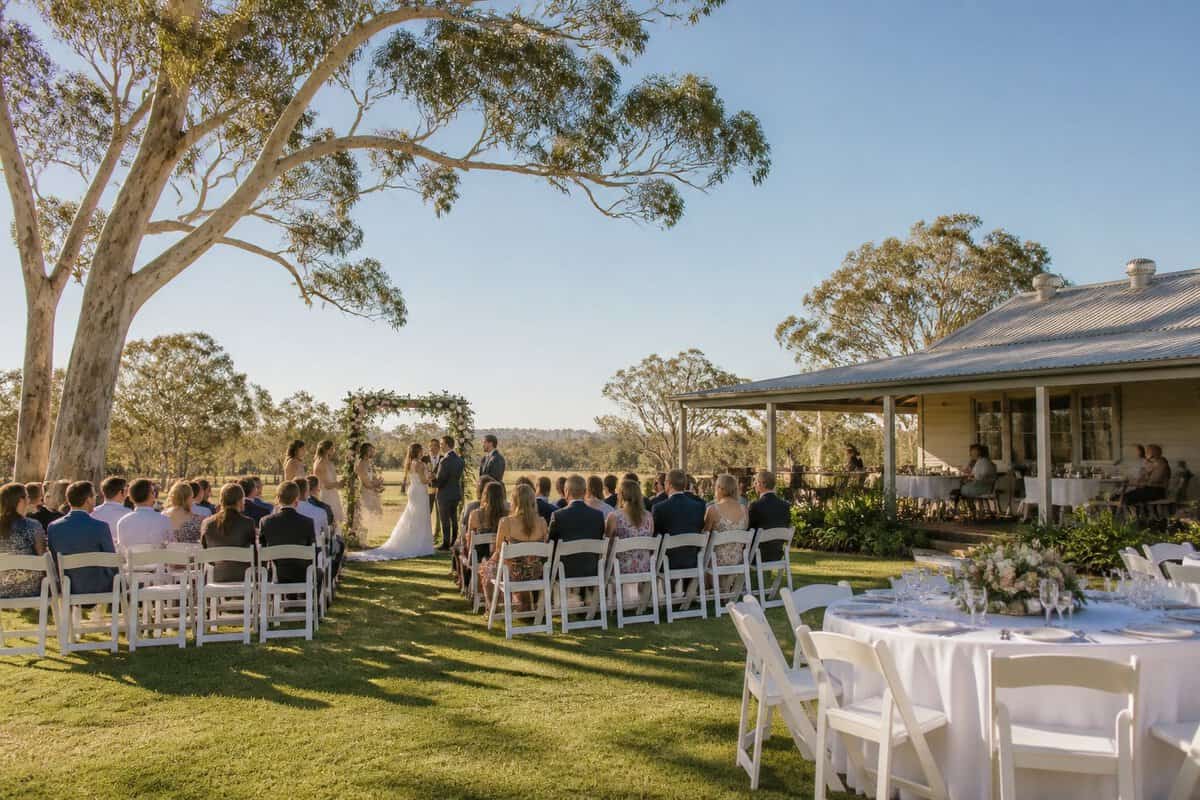 An affordable outdoor wedding venue with white chairs, a floral arch, and a simple reception area surrounded by greenery.
