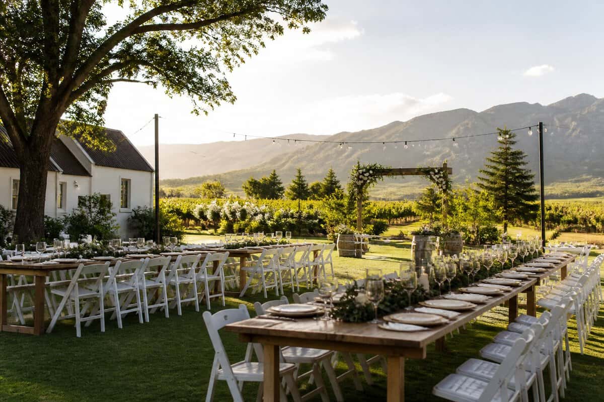 An elegant outdoor wedding setup at a modest venue surrounded by Paarl vineyards and mountains.