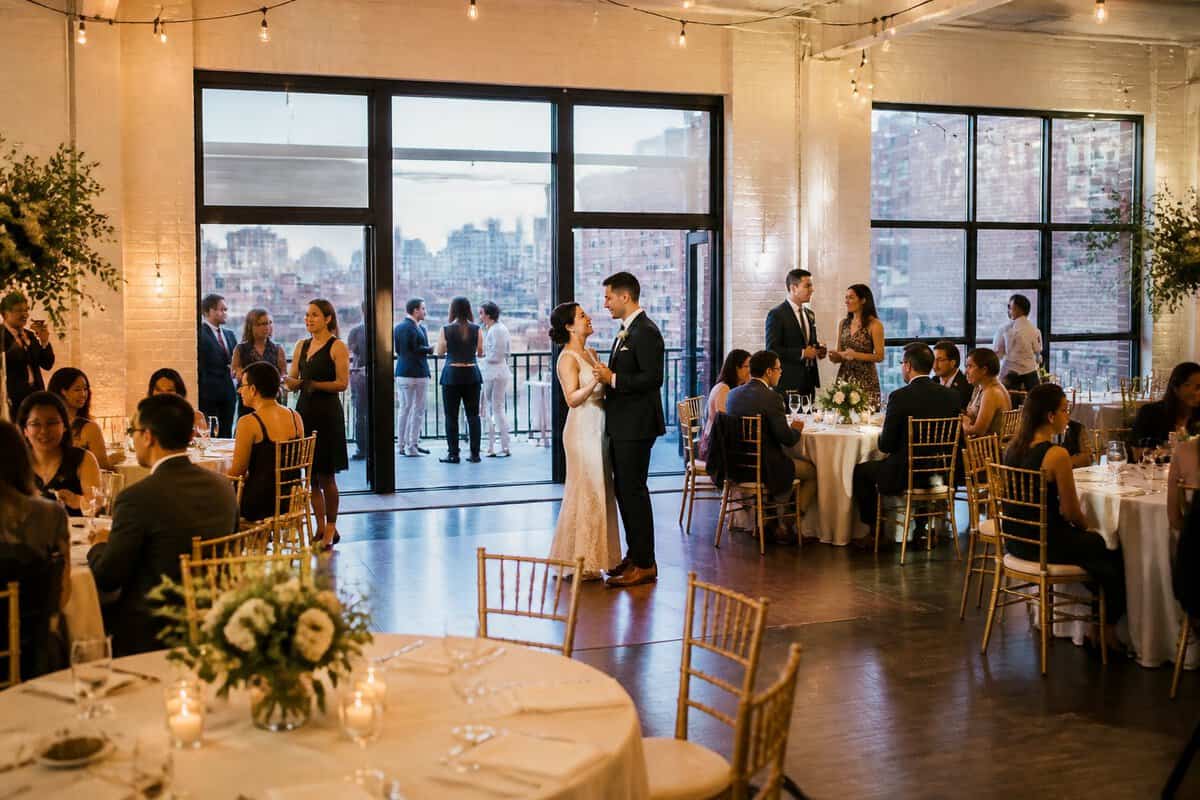 A couple and guests celebrate at an elegantly decorated wedding reception in a Queens event venue.