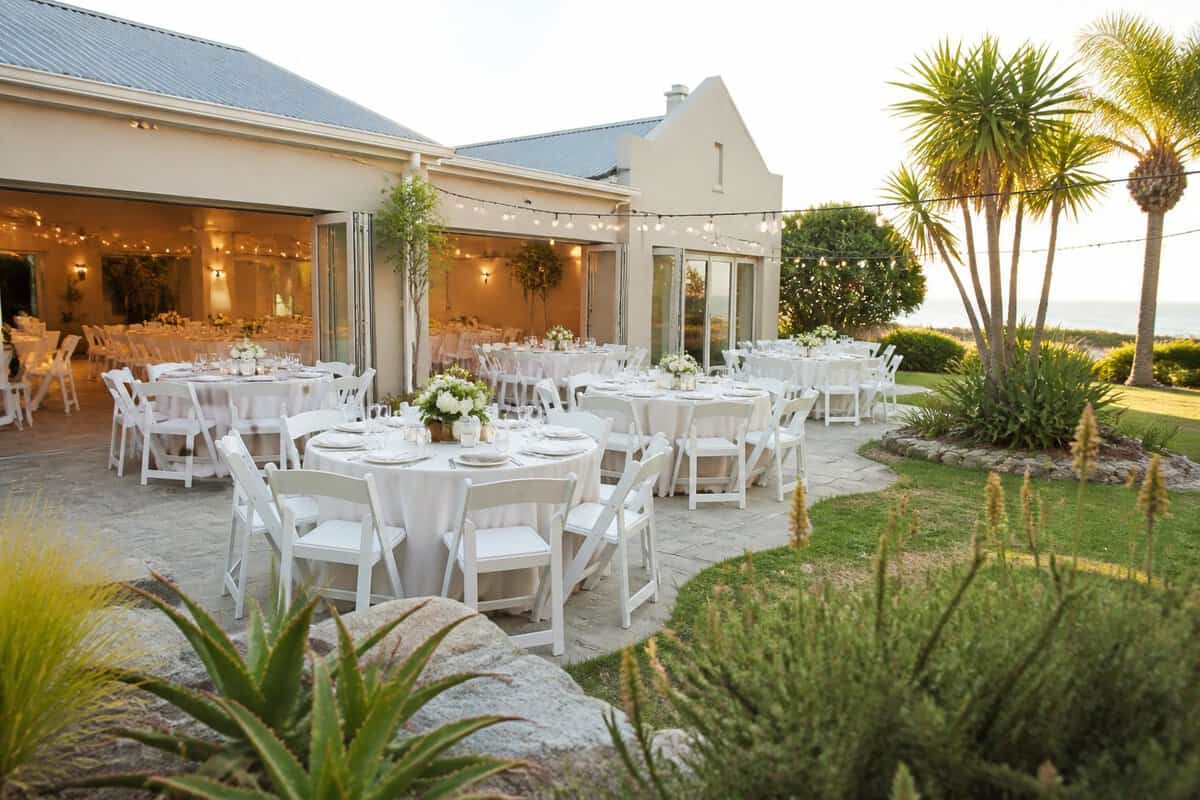 An affordable wedding venue with simple decorated tables in a sunny landscaped courtyard.