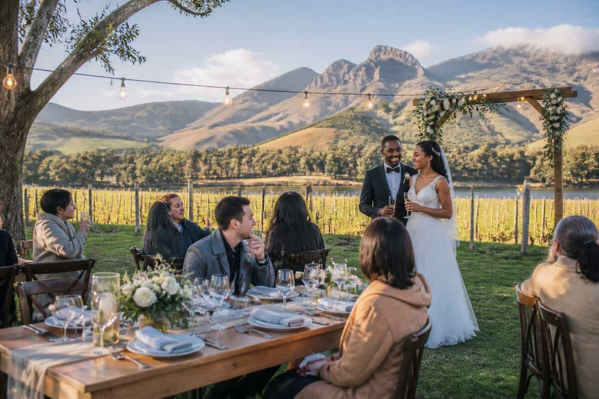 An intimate wedding reception at a vineyard venue with mountains in the background.