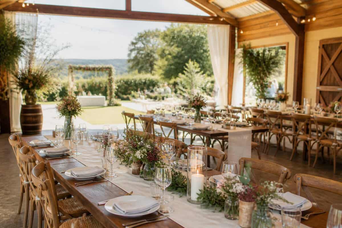 A warmly decorated wedding reception venue opening onto a green garden.