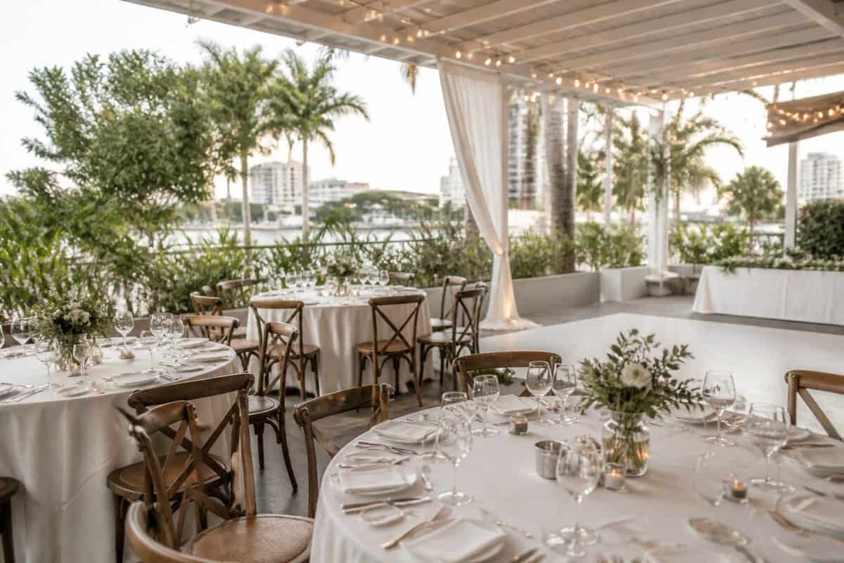 An affordable wedding reception venue in Brisbane with simple floral décor, outdoor seating, greenery, and warm lighting.