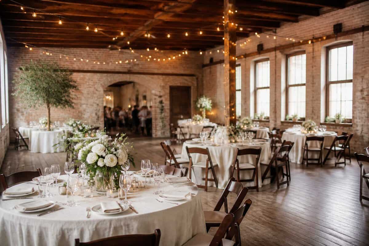 An elegant, modest wedding reception set up in a warmly lit converted venue.