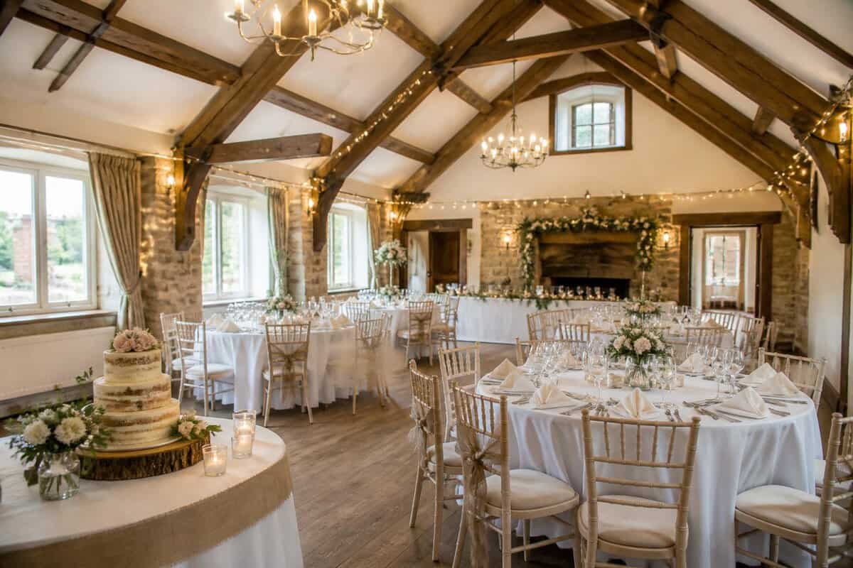 An affordable wedding reception set up in a charming countryside venue with decorated tables and warm lighting.