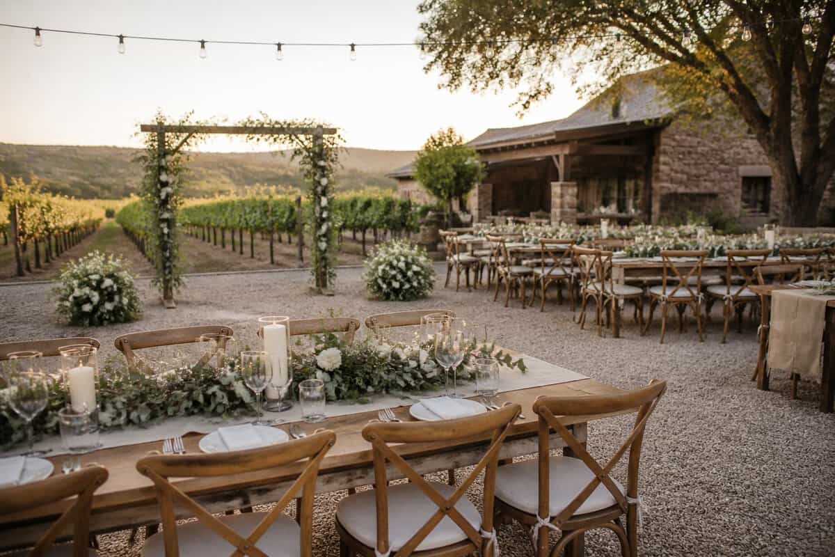 An intimate wedding reception set up beside a vineyard and winery.