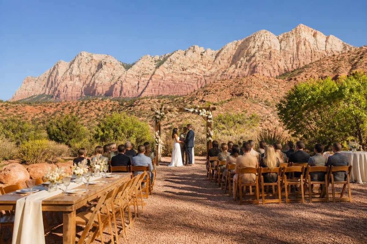 A modest outdoor wedding venue with simple decorations set against red cliffs near Zion National Park.