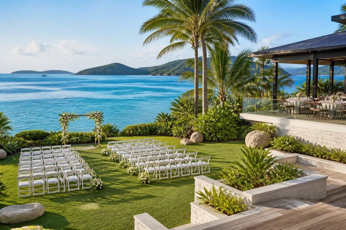 A tropical wedding venue on a manicured lawn overlooking turquoise water and green Whitsunday islands.