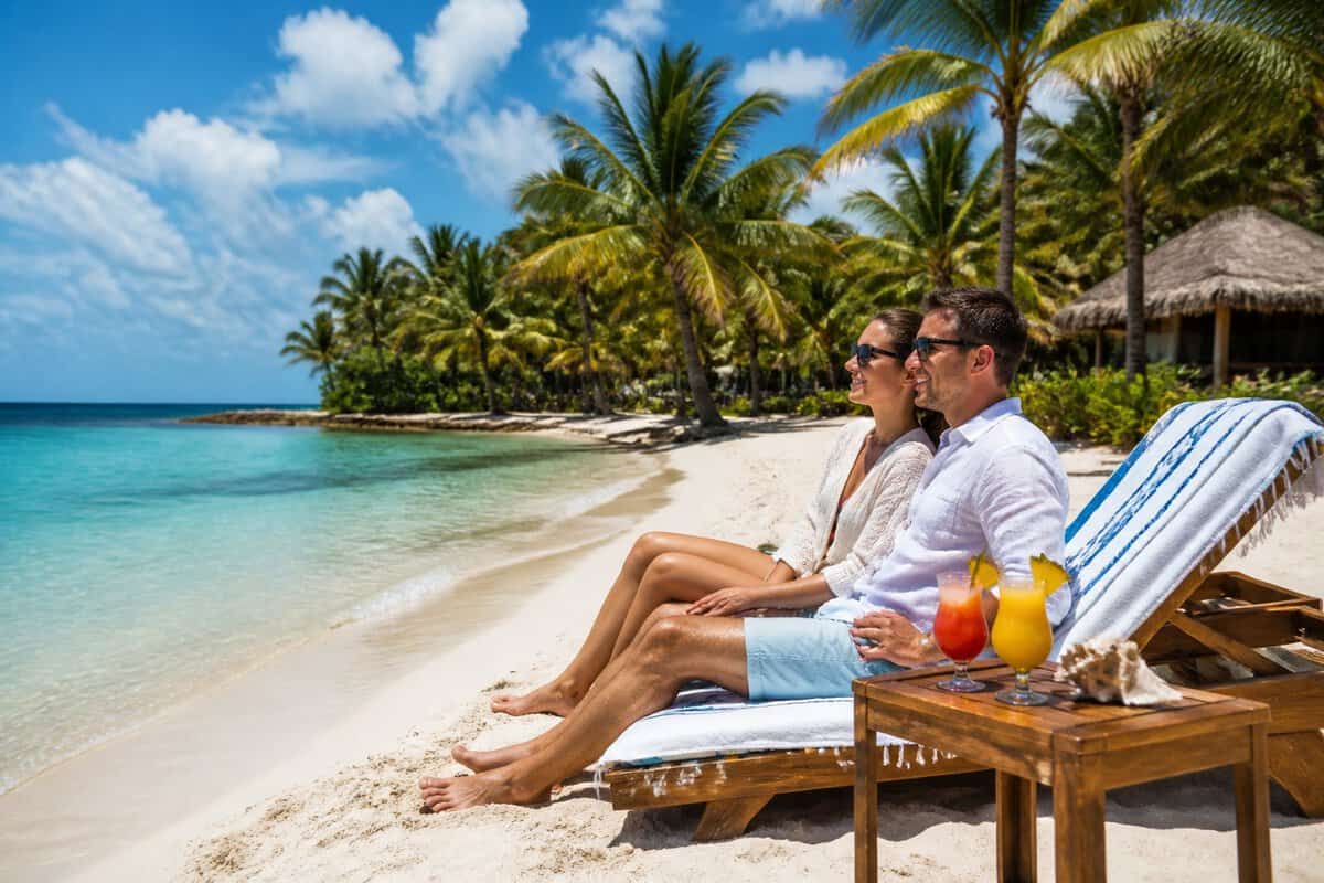 Newlywed couple relaxing on a sunny Belize beach beside a tropical resort.