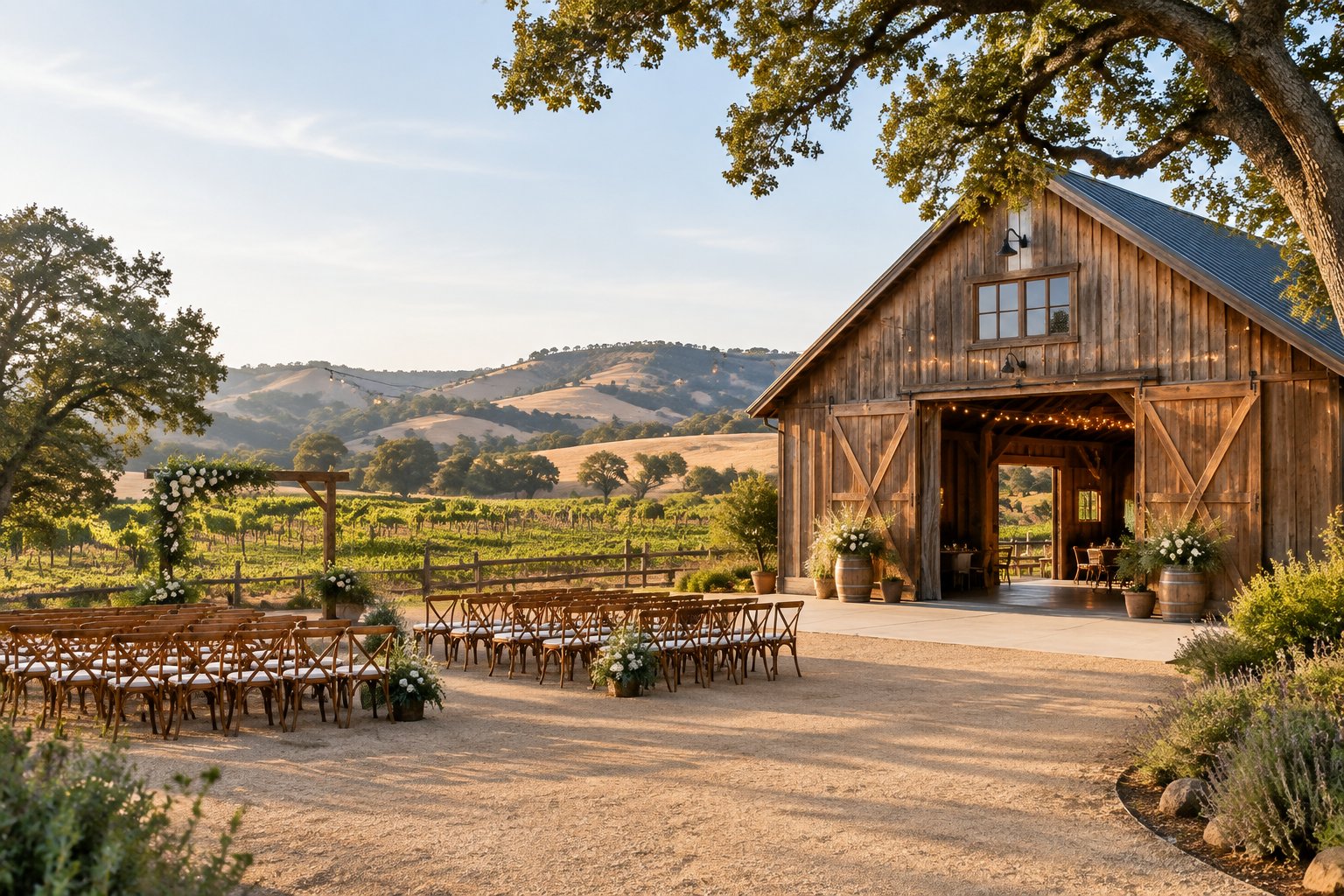 A rustic barn wedding venue surrounded by vineyards, oak trees, and rolling countryside.
