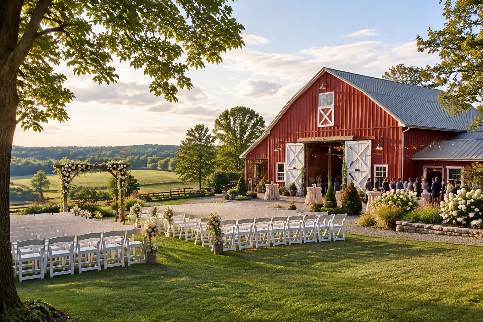 A rustic red barn wedding venue surrounded by green countryside, with white ceremony chairs and a floral arbor.