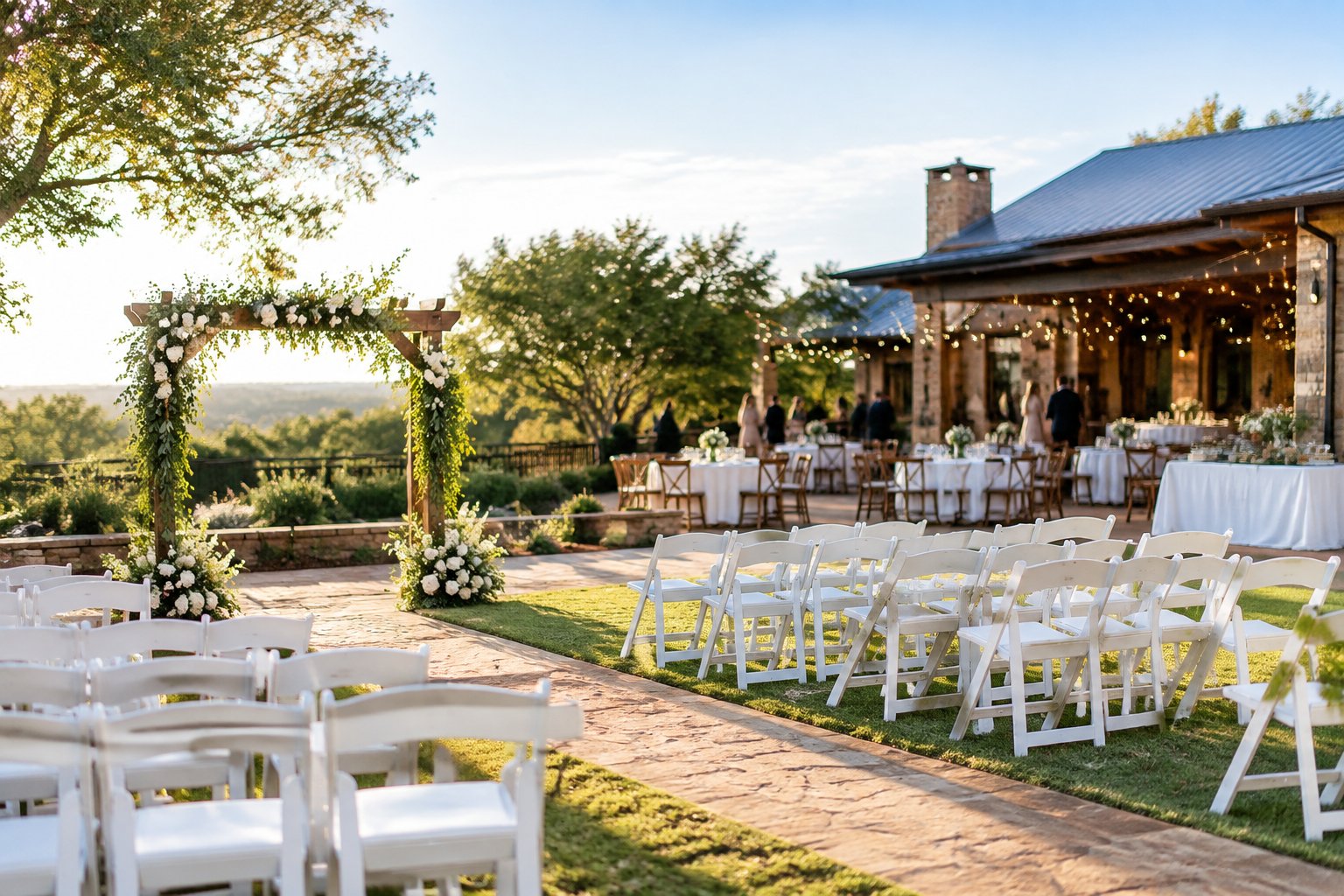 An affordable outdoor wedding venue with simple white chairs, greenery, string lights, and modest reception tables.