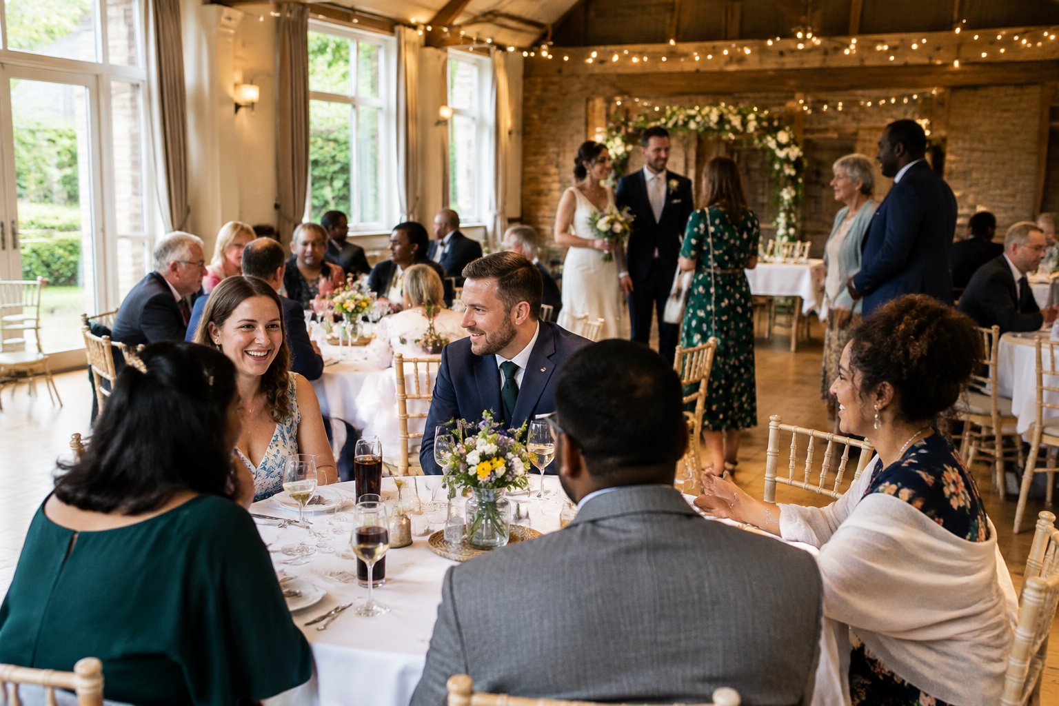 A newlywed couple and guests celebrate in a warmly decorated, affordable countryside wedding venue.