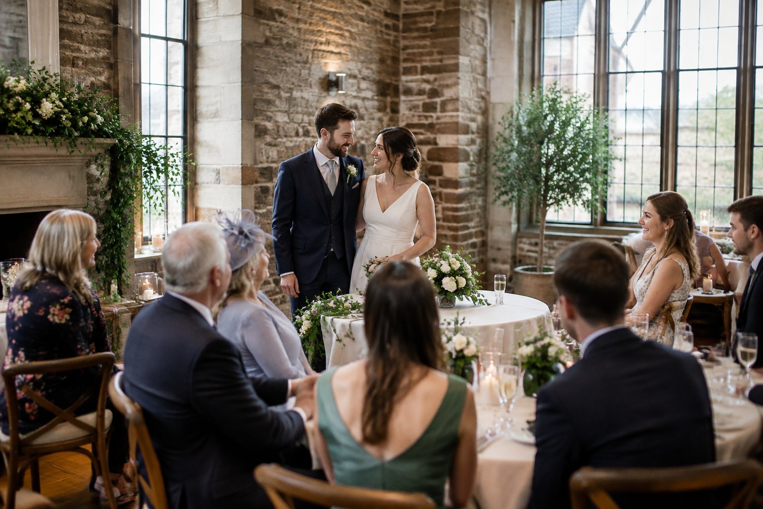 A couple celebrates with family and friends in a small wedding reception room.