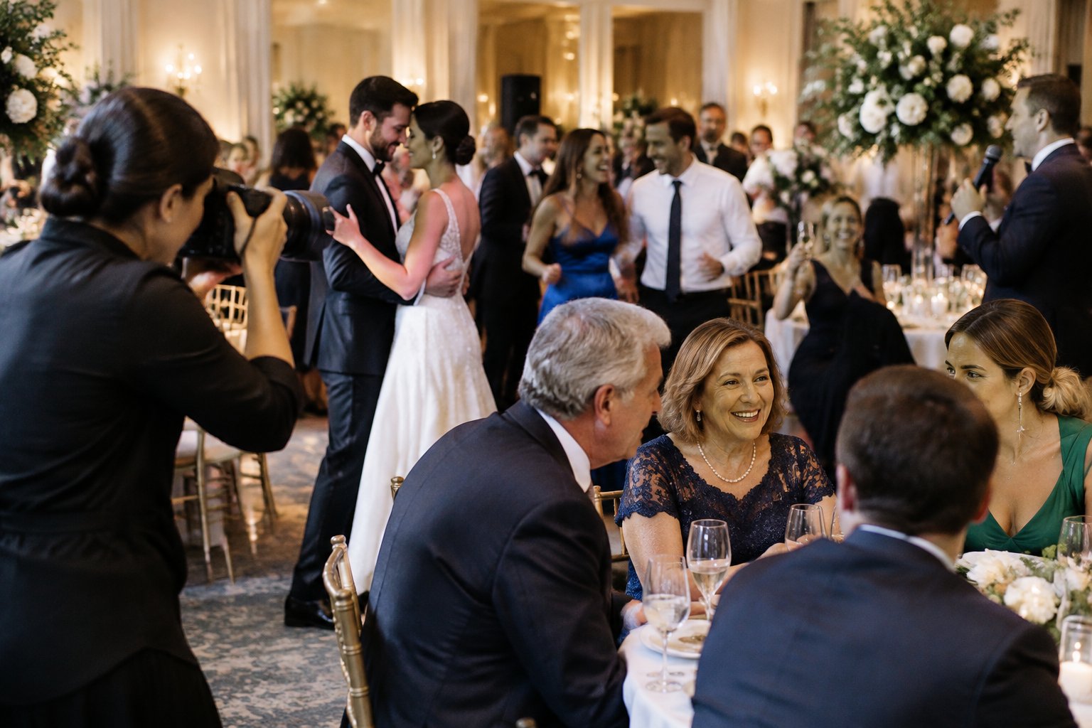 A wedding photographer captures the newlyweds and their guests enjoying a reception.