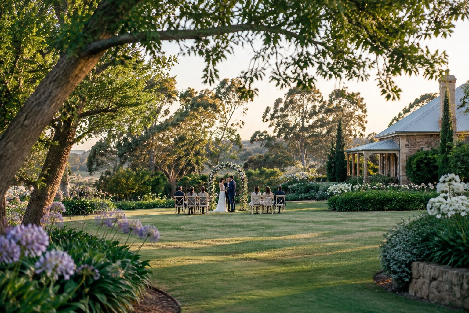 A couple stands beneath a flower arch at a small garden wedding.
