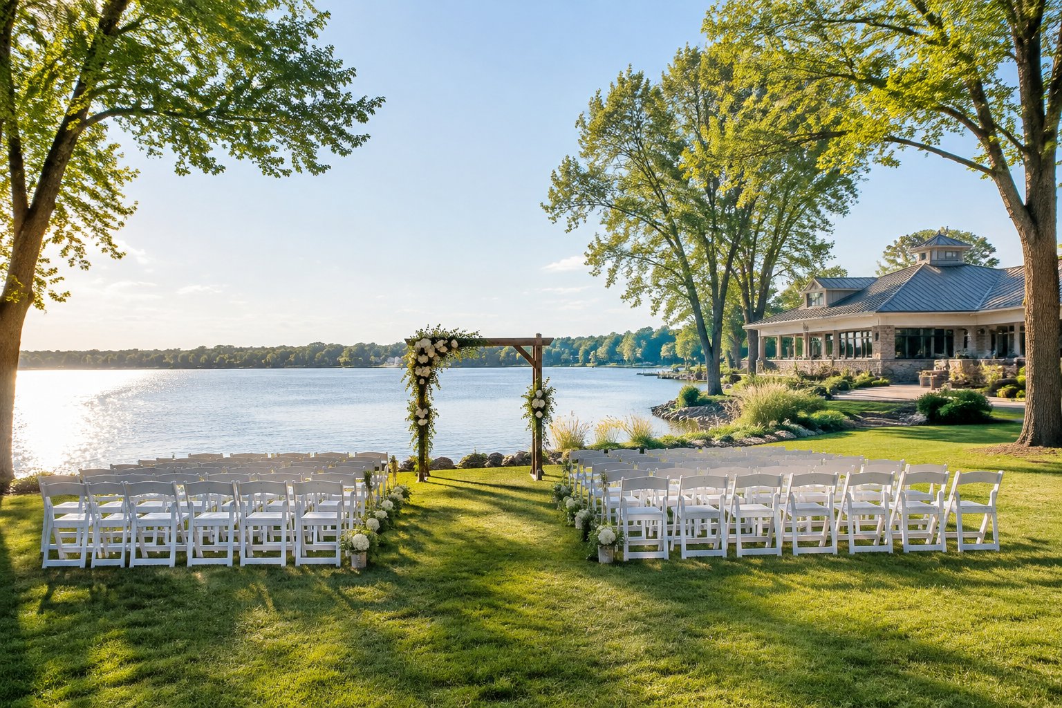 A wedding ceremony setup on a grassy lakeshore.