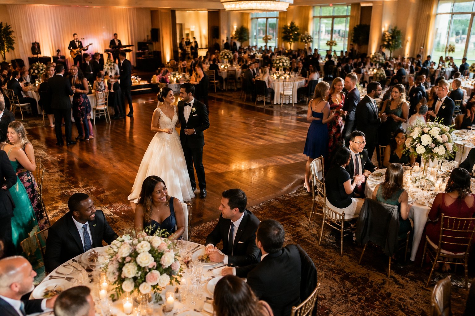 A couple celebrates with guests at a large wedding reception.