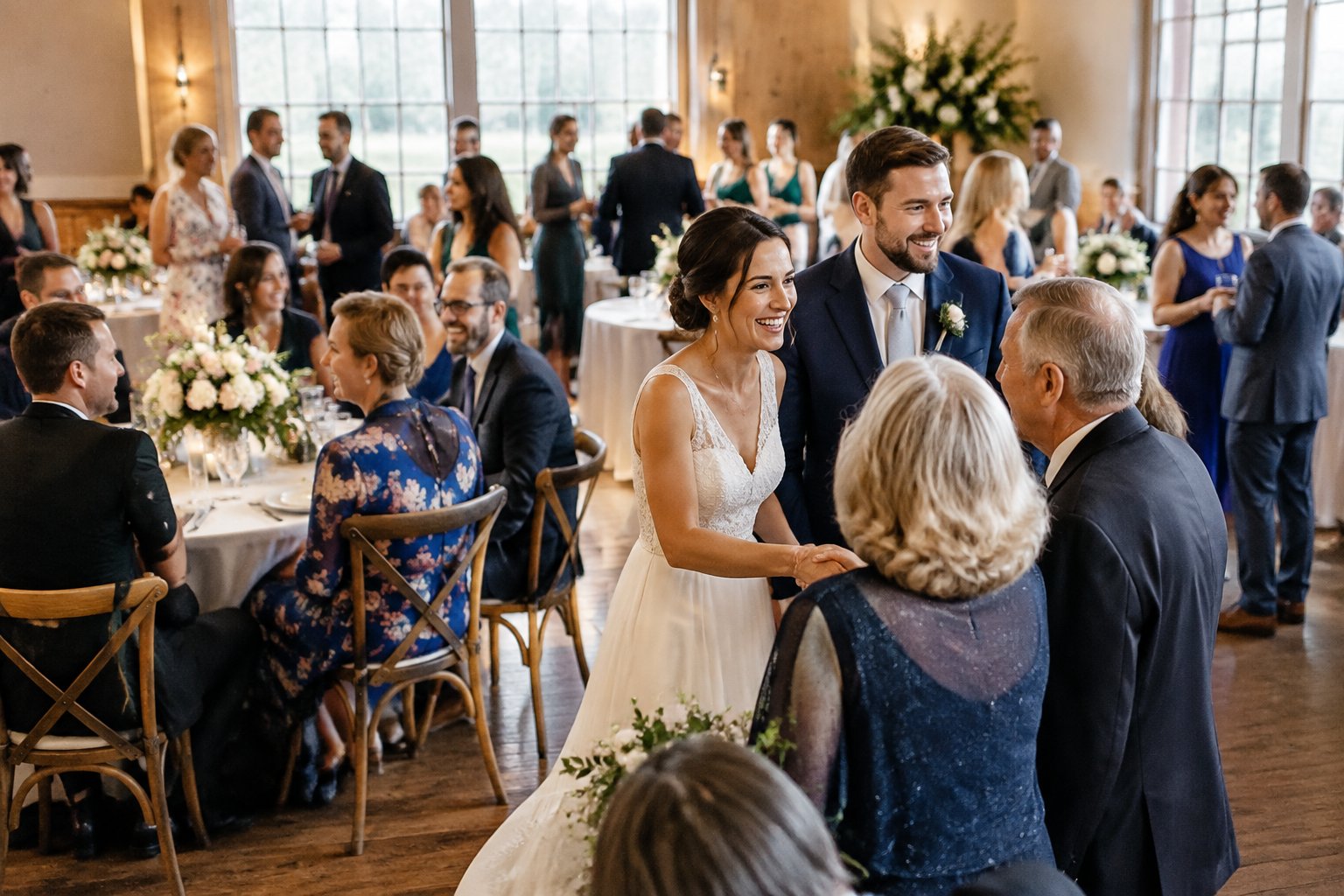 A couple greets guests at a wedding reception.